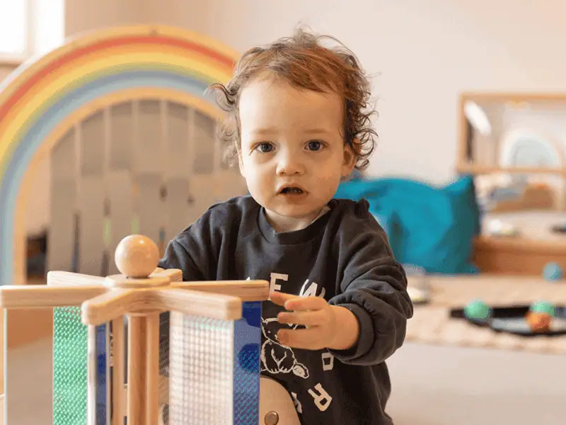 Monkey Puzzle Day Nursery West Acton Young child playing with wooden toys at Monkey Puzzle Day Nursery West Acton.